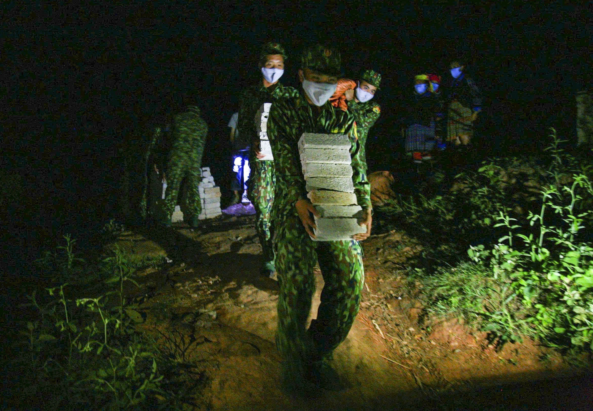 De nuit, des soldats du poste de garde-frontière de Na Bung acheminent des matériaux de construction, s'engageant à offrir un foyer aux familles les plus défavorisées de la région. Photo: VNA anh-2-15.jpg