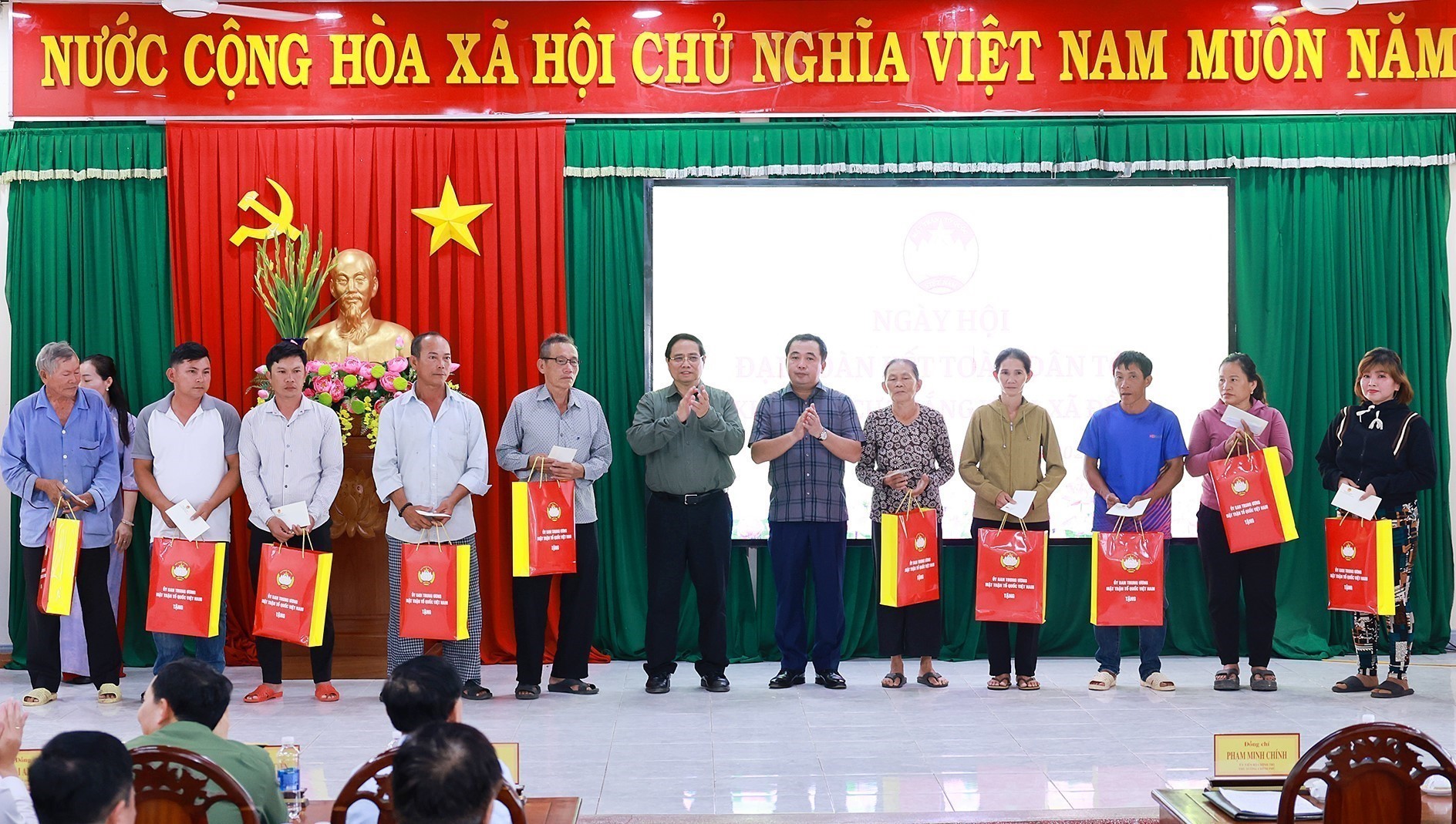 Le Premier ministre Pham Minh Chinh remet des cadeaux à des familles bénéficiaires de politiques sociales. Photo: VNA