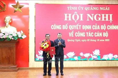 Le Minh Hung, membre du Bureau politique, secrétaire du Comité central du Parti et président de sa Commission d'organisation (droite) félicite Ho Van Nien. Photo ; VNA