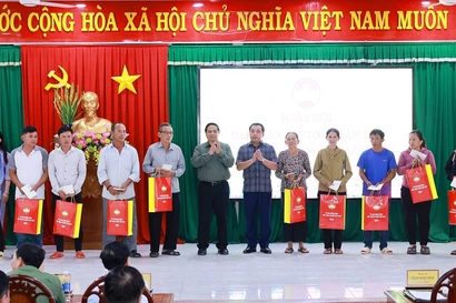 Le Premier ministre Pham Minh Chinh remet des cadeaux à des familles bénéficiaires de politiques sociales. Photo: VNA