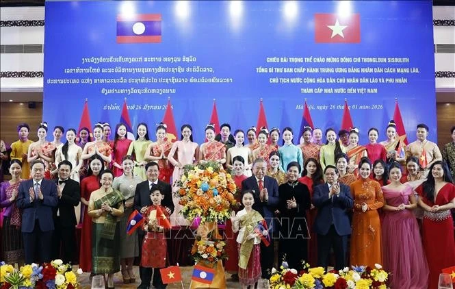 Le secrétaire général du Parti communiste du Vietnam (PCV), To Lam, et son épouse, le secrétaire général du Parti populaire révolutionnaire du Laos (PPRL) et président du Laos, Thongloun Sisoulith, et son épouse, avec des artistes lors de l'événement. Photo: VNA