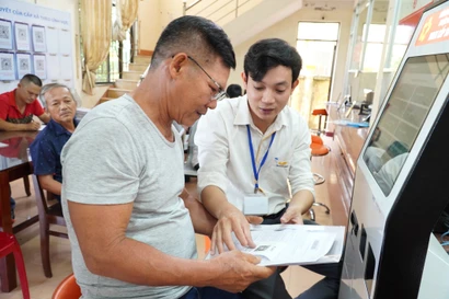 Un fonctionnaire aide un habitant dans ses démarches administratives à Quang Ngai. Photo : VNA