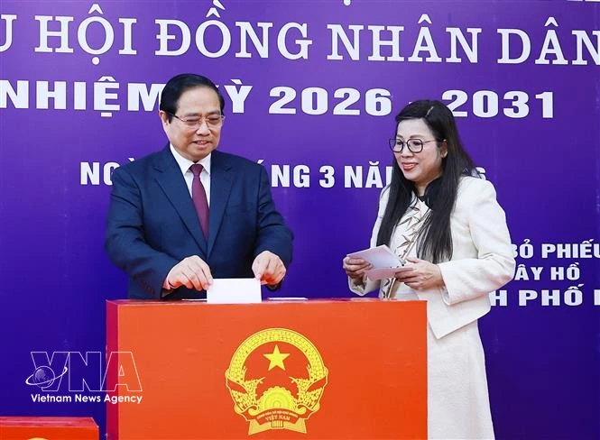 Le Premier ministre Pham Minh Chinh et son épouse déposent leurs bulletins de vote dans l'urne. Photo: VNA