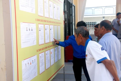 Des électeurs issus des minorités ethniques de la commune de Bắc Bình (Lâm Dông) consultent les biographies des candidats avant le jour du scrutin. Photo : VNA