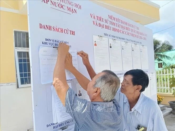 Des électeurs consultent les informations concernant les candidats à la 16e Assemblée nationale et aux conseils populaires à tous les niveaux pour le mandat 2026-2031. (Photo publiée par VNA)
