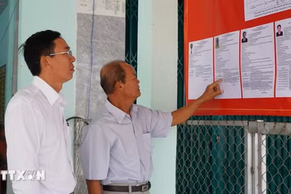 Des électeurs consultent les brèves biographies des candidats au Conseil populaire de la commune de Tan Hong, province de Dong Thap, mandat 2026-2031. Photo : VNA