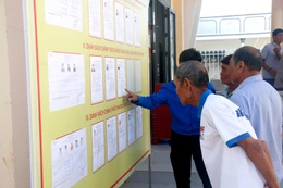 Des électeurs issus des minorités ethniques de la commune de Bắc Bình (Lâm Dông) consultent les biographies des candidats avant le jour du scrutin. Photo : VNA