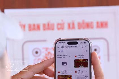Les électeurs scannent un code QR à l’aide de leur smartphone afin de vérifier rapidement les informations relatives à leur droit de vote. Photo : VNA