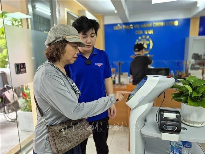 Des habitants effectuent des opérations sur un robot d’IA assistant les démarches administratives au quartier de Cua Nam. Photo d’illustration : VNA