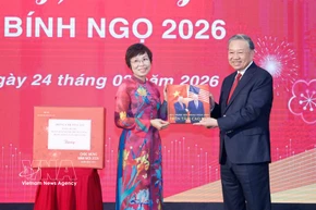 La directrice générale de la VNA, Vu Viet Trang, remet au secrétaire général To Lam un ouvrage photographique réalisé par les journalistes du Département de rédaction des photos de presse. Photo : VNA