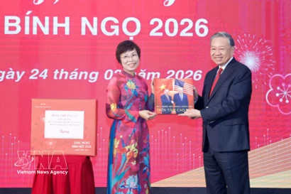 La directrice générale de la VNA, Vu Viet Trang, remet au secrétaire général To Lam un ouvrage photographique réalisé par les journalistes du Département de rédaction des photos de presse. Photo : VNA