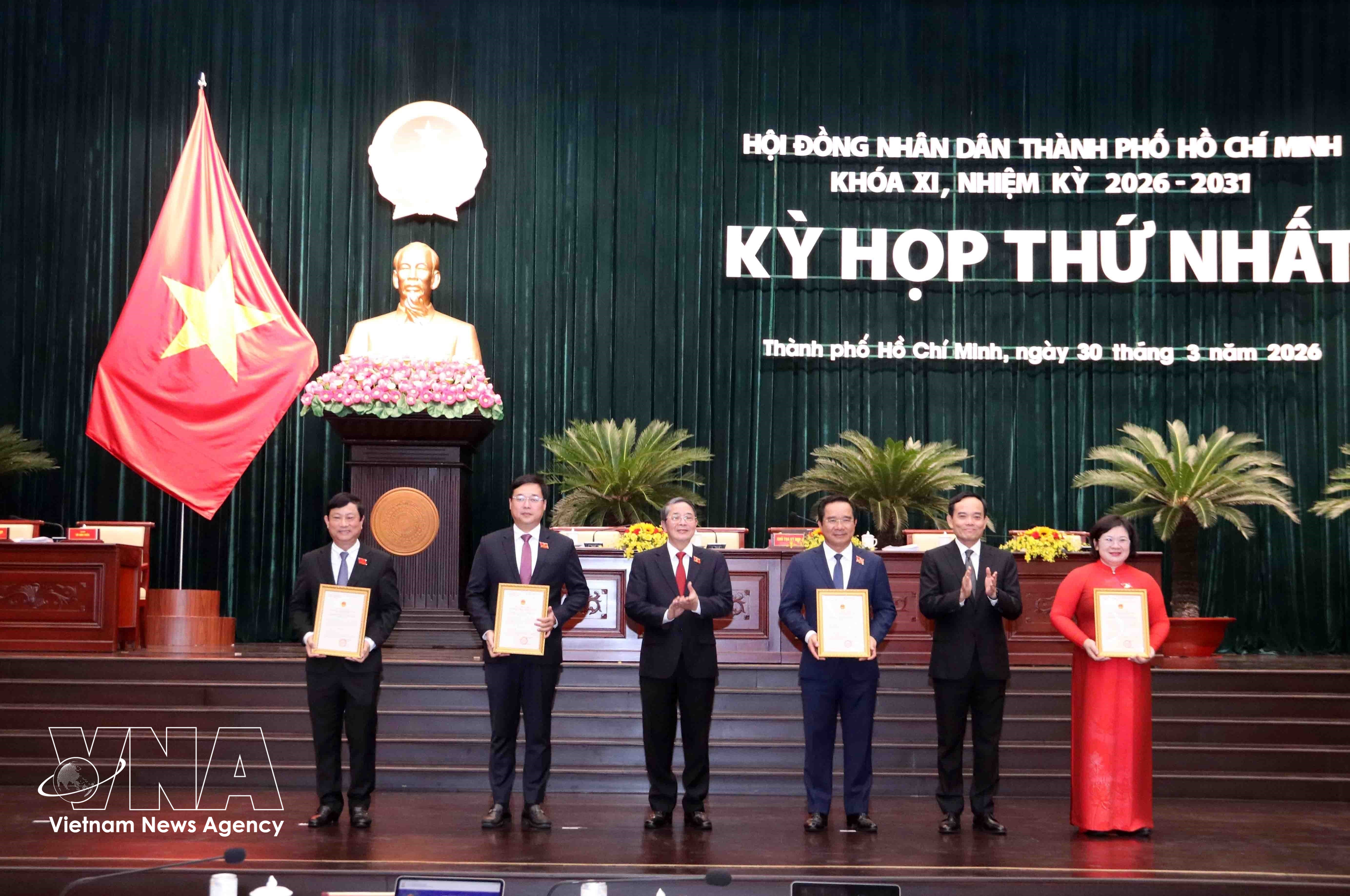 Trân Luu Quang (2e à partir de la droite), membre du Bureau politique et secrétaire du Comité du Parti de Hô Chi Minh-Ville, et Nguyên Duc Hai (3e à partir de la gauche), vice-président de l'Assemblée nationale, remettent les décisions de reconnaissance aux membres du Conseil populaire municipal. Photo: VNA
