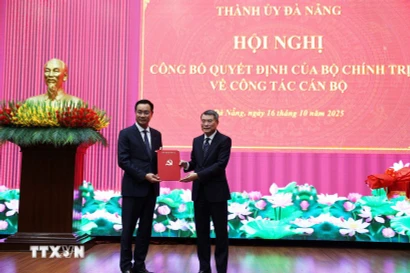 Le secrétaire du Comité central du Parti et chef de la Commission d’organisation du Comité central, Le Minh Hung (gauche), remet la décision du Bureau politique portant sur la mutation, l’affectation et la désignation de Le Ngoc Quang, membre du Comité central et secrétaire du Comité du Parti de Quang Tri, au poste de secrétaire du Comité du Parti de la province de Da Nang pour le mandat 2025–2030. Photo: VNA