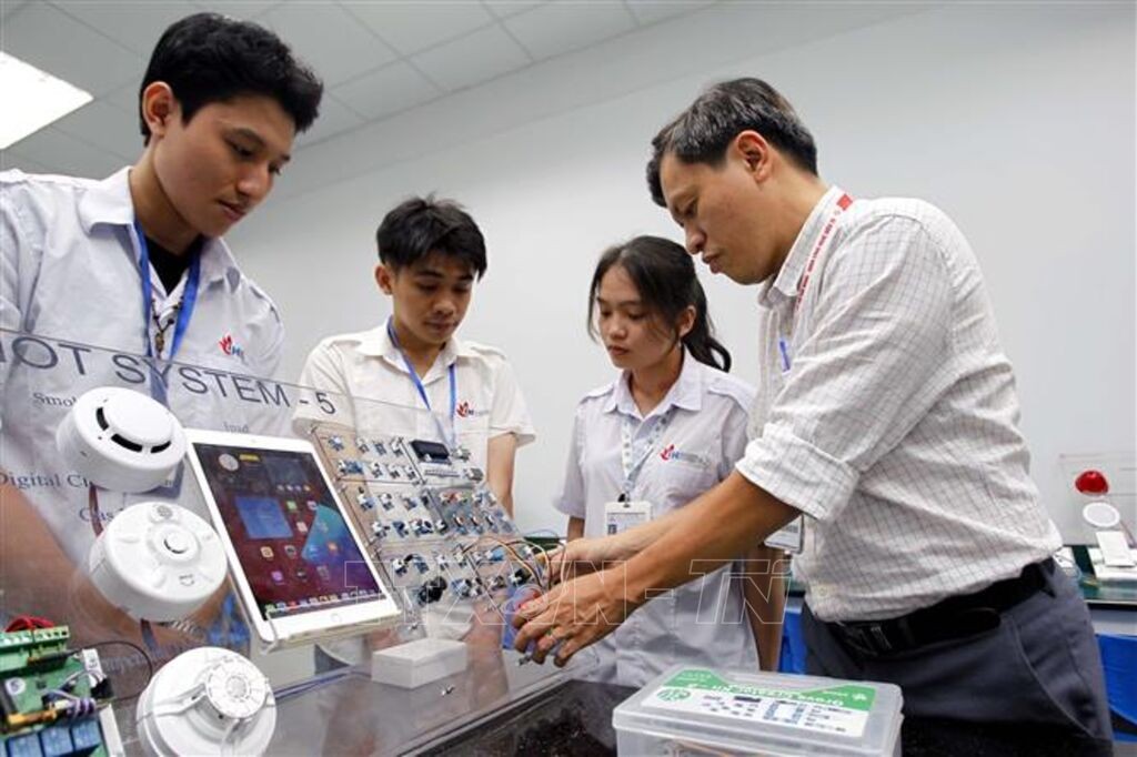 Un enseignant de la Faculté de Technologie électronique de l'Université Industrielle de Ho Chi Minh-Ville guide ses étudiants dans leurs travaux et recherches au laboratoire IoT et Intelligence Artificielle. Photo: VNA