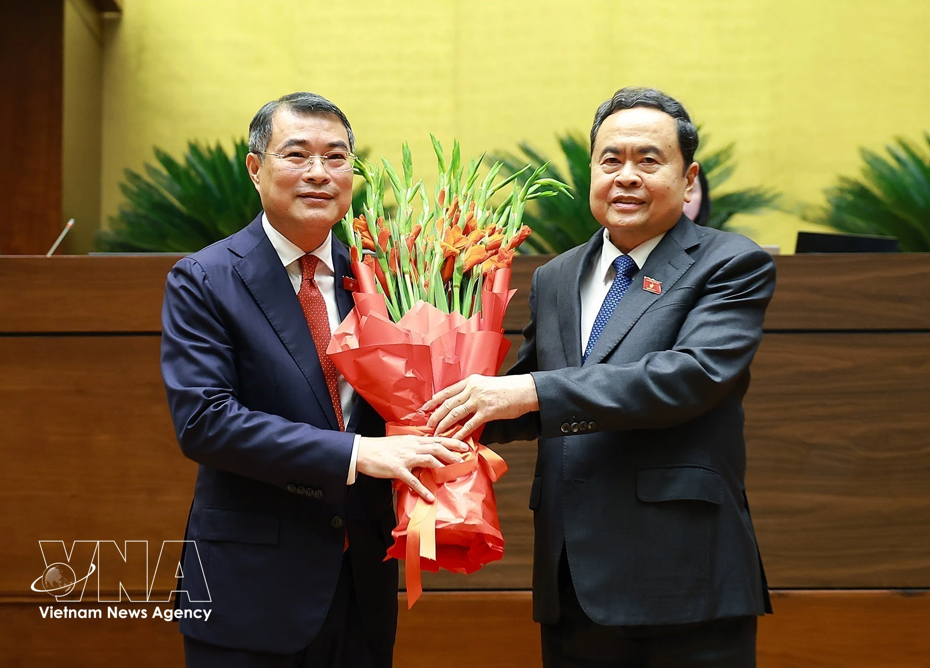 Le président de l'Assemblée nationale, Tran Thanh Man, au nom du Parti, de l'État, des dirigeants du Front de la patrie du Vietnam et des députés de la 16e législature, offre des fleurs au Premier ministre Le Minh Hung. Photo : VNA