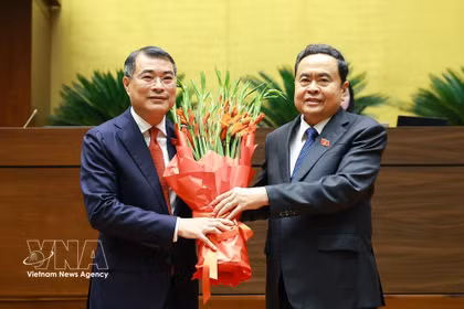 Le président de l'Assemblée nationale, Tran Thanh Man, au nom du Parti, de l'État, des dirigeants du Front de la patrie du Vietnam et des députés de la 16e législature, offre des fleurs au Premier ministre Le Minh Hung. Photo : VNA