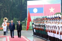 Les dirigeants To Lam et Thongloun Sisoulith passent en revue la garde d'honneur de l'Armée populaire vietnamienne. Photo: VNA