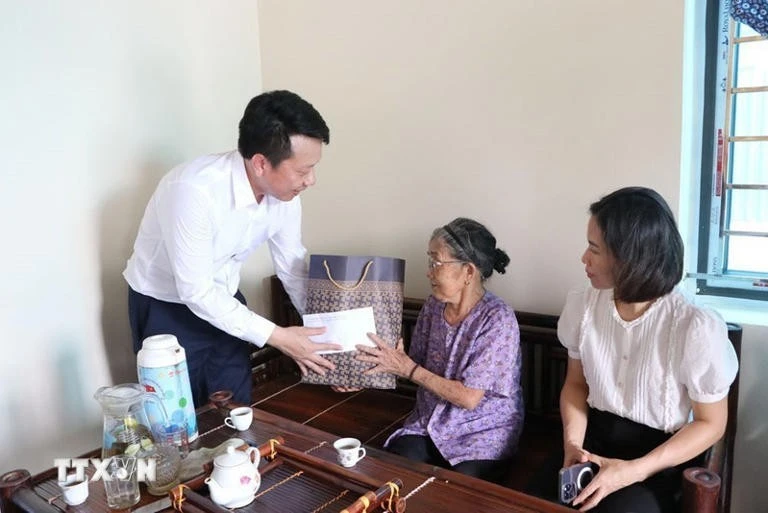 Remise de cadeaux à une femme méritante. Photo: VNA