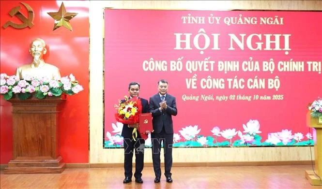 Le Minh Hung, membre du Bureau politique, secrétaire du Comité central du Parti et président de sa Commission d'organisation (droite) félicite Ho Van Nien. Photo ; VNA