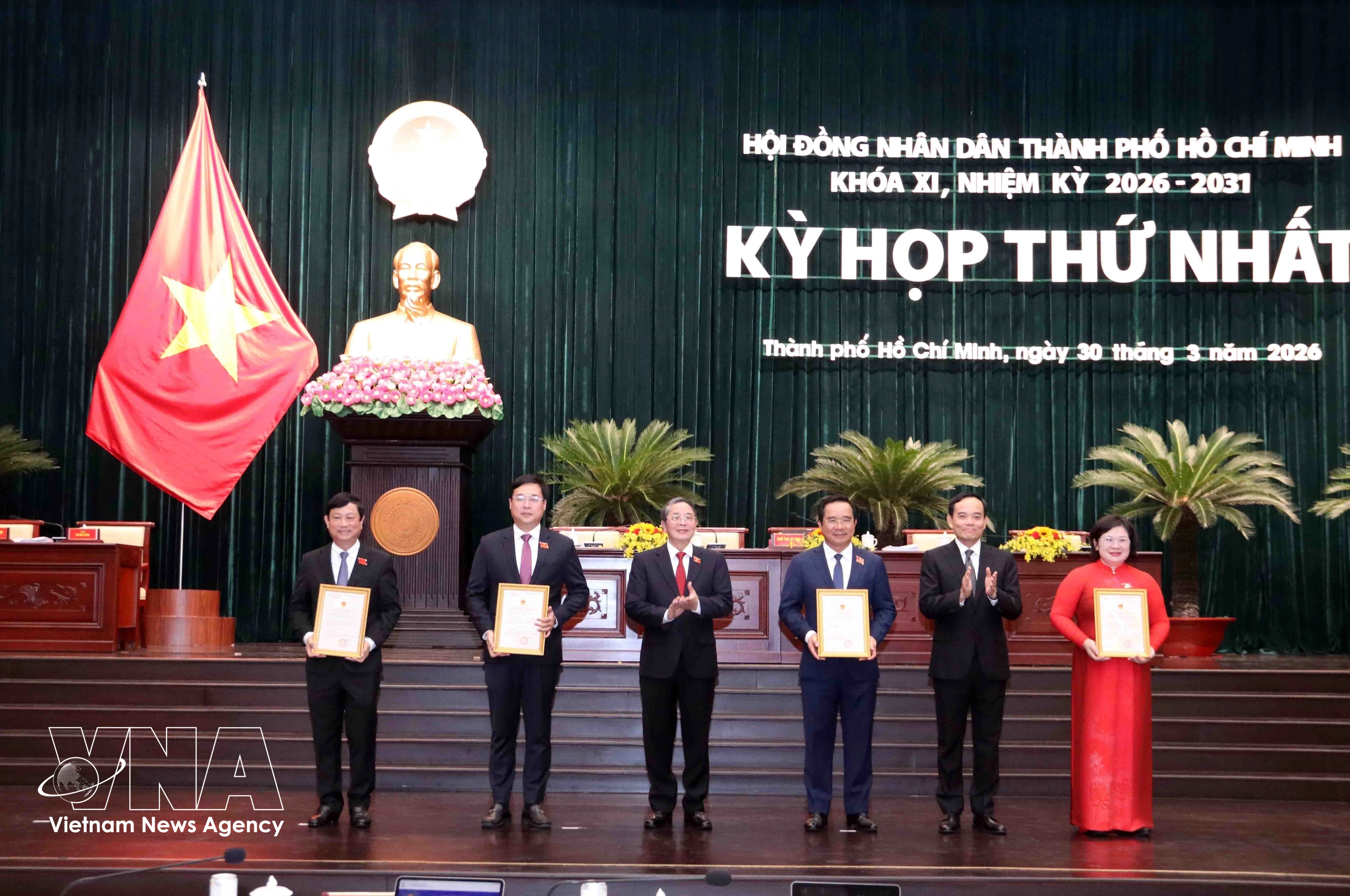 Trân Luu Quang (2e à partir de la droite), membre du Bureau politique et secrétaire du Comité du Parti de Hô Chi Minh-Ville, et Nguyên Duc Hai (3e à partir de la gauche), vice-président de l'Assemblée nationale, remettent les décisions de reconnaissance aux membres du Conseil populaire municipal. Photo: VNA